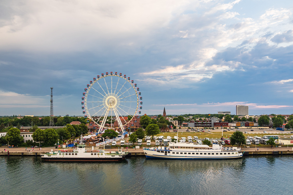 Riesenrad und Leuchtturm an der Ostseeküste in Warnemünde am Abend | Riesenrad und Leuchtturm an der Ostseeküste in Warnemünde am Abend.