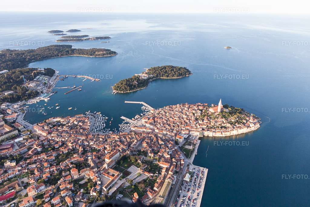 Vue aérienne: Vue de la ville sur la côte méditerranéenne près de la vieille ville de Rovinj en Istarska Župania - Istrie, Croatie. Le promontoire proéminent se situe sur la côte ouest de la péninsule istrienne. à Rovinj dans le département Gespanschaft Istrien, Croatie. Photo: IMG_106268.jpg prise le 14/04/2018 par Werner Riehm/FLY-FOTO.eu – Résolution de l'original: 5472 x 3648 px