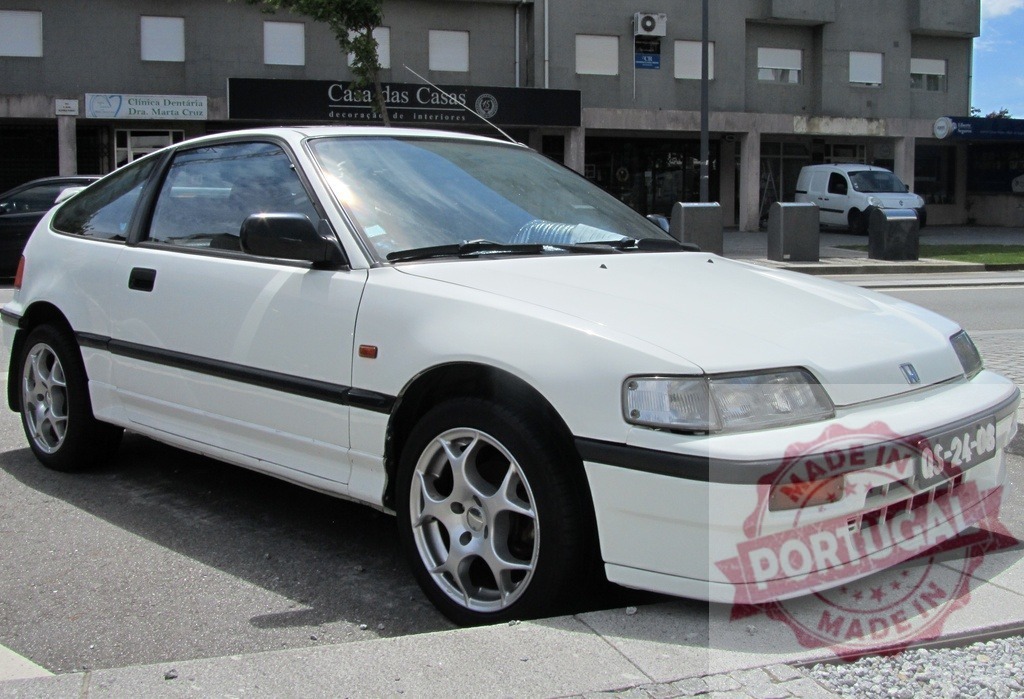 White Honda CRX parked on the street in Portugal | Classic white Honda CRX parked on a sunny street in Portugal, showing its timeless design - Realisiert mit Pictrs.com