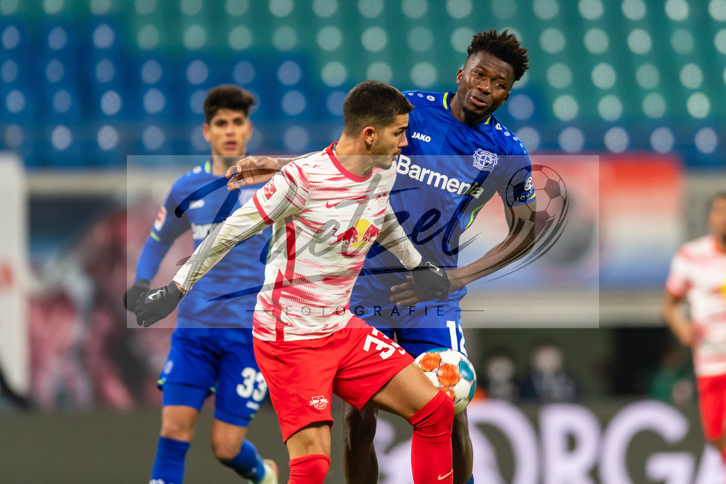 RBLLEV20211128_081 | Fussball, Herren: Andre Silva (RB Leipzig) und Edmond Tapsoba (Bayer 04 Leverkusen) im Zweikampf bei dem Spiel der 1. Bundesliga zwischen RB Leipzig und Bayer 04 Leverkusen in der Red Bull Arena am 28.11.2021 in Leipzig, Deutschland.DFB / DFL REGULATIONS PROHIBIT ANY USE OF PHOTOGRAPHS AS IMAGE SEQUENCES AND/OR QUASI-VIDEO. - Realisiert mit Pictrs.com