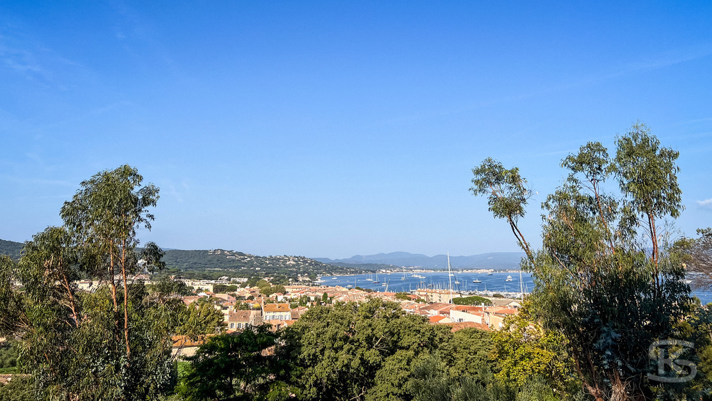 Panoramablick über den Golf von Saint-Tropez – Côte d’Azur | Weitläufiger Panoramablick über grüne Baumkronen auf das Dorf Saint-Tropez und das tiefblaue Mittelmeer im Golf unter strahlend blauem Himmel. - Realisiert mit Pictrs.com