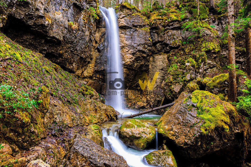 Sibli Wasserfall am Tegernsee | Das Bild zeigt den Sibli-Wasserfall in Bayern, Deutschland. Der Wasserfall befindet sich südwestlich des Tegernsees, in der Nähe von Rottach-Egern. Er hat eine Fallhöhe von etwa 12 bis 15 Metern. Der Wasserfall ist über die mautpflichtige Enterrottach-Straße erreichbar und liegt nur einen kurzen Spaziergang vom Wanderparkplatz Kistenwinterstube entfernt. Der Sibli-Wasserfall ist ein ruhiger, versteckter Ort im Wald, ideal für eine Wanderung, besonders an heißen Sommertagen.  - Realisiert mit Pictrs.com