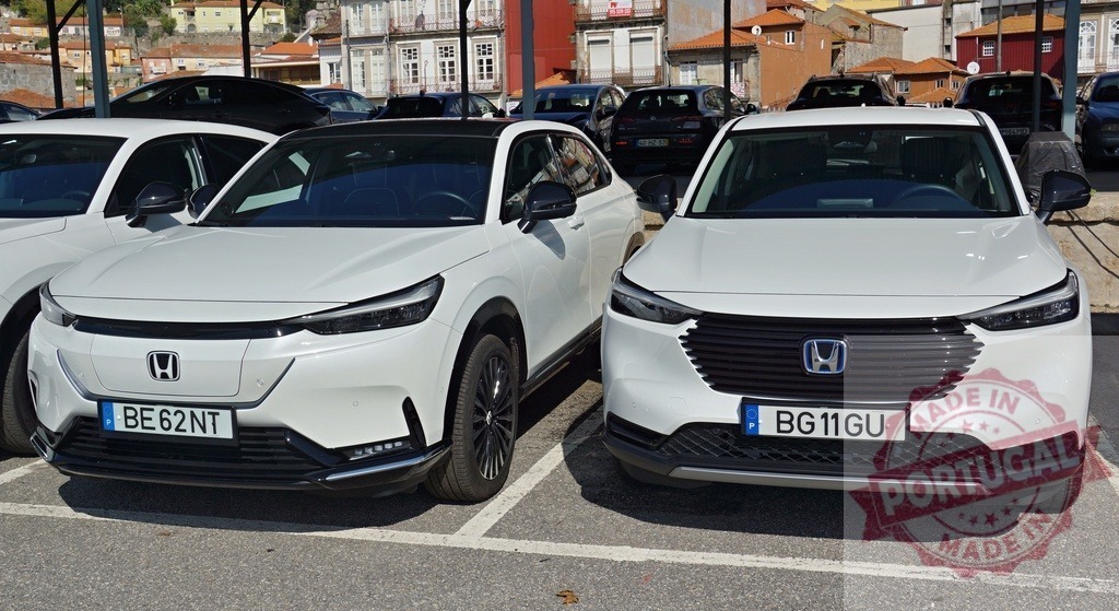 Honda e:Ny1 and HR-V parked side by side | Honda e:Ny1 electric SUV and HR-V hybrid SUV parked in a lot, showcasing automotive technology - Realisiert mit Pictrs.com