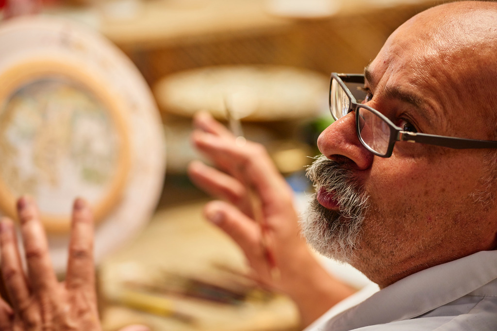 Maestro Caravaggi bemalt den Teller | Deruta, Italien - August 31, 2016: Keramikmanufaktur Torretti; Maestro Caravaggi bemalt einen Teller. - Realisiert mit Pictrs.com