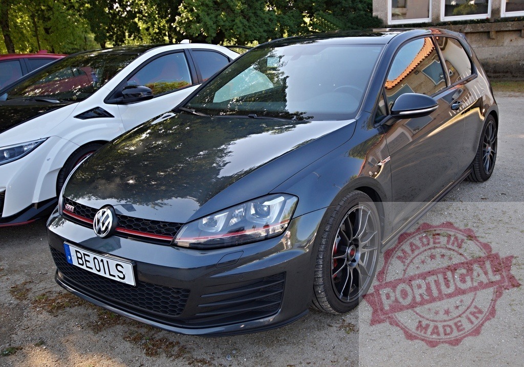 Volkswagen Golf GTI parked at car meet event | Dark grey Volkswagen Golf GTI parked on gravel next to a white car - Realisiert mit Pictrs.com