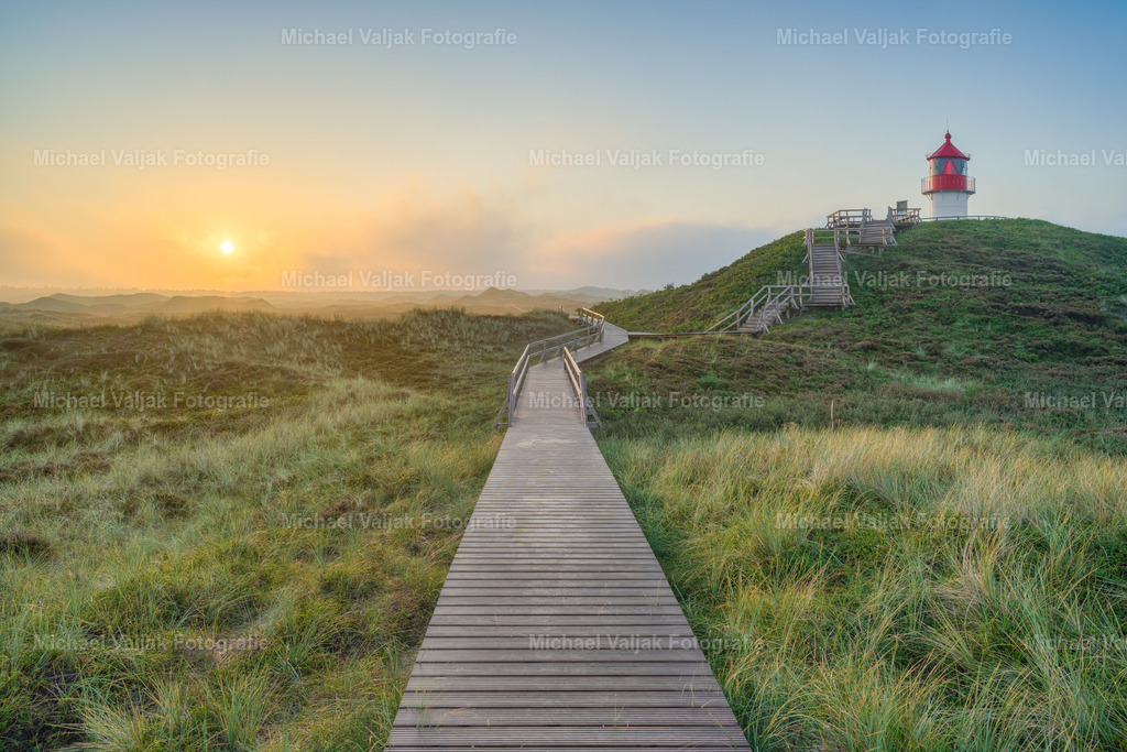 Quermarkenfeuer bei Norddorf auf Amrum | Das Quermarkenfeuer in Norddorf auf Amrum ist ein historischer Leuchtturm, der seit über einem Jahrhundert den Schiffen den Weg weist. Besucher können den Leuchtturm erreichen und den Ausblick auf die Nordsee genießen. Bei gutem Wetter ist sogar der Leuchtturm von Hörnum sichtbar. Dieser Ort verbindet Natur und Geschichte und ist ein schöner Ort für einen ruhigen Morgen. - Realisiert mit Pictrs.com