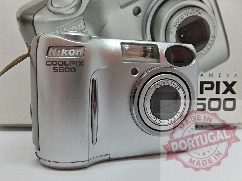 Nikon COOLPIX 5600 digital camera displaying technology product | Nikon COOLPIX 5600 silver digital camera presenting electronic device - Realized with Pictrs.com