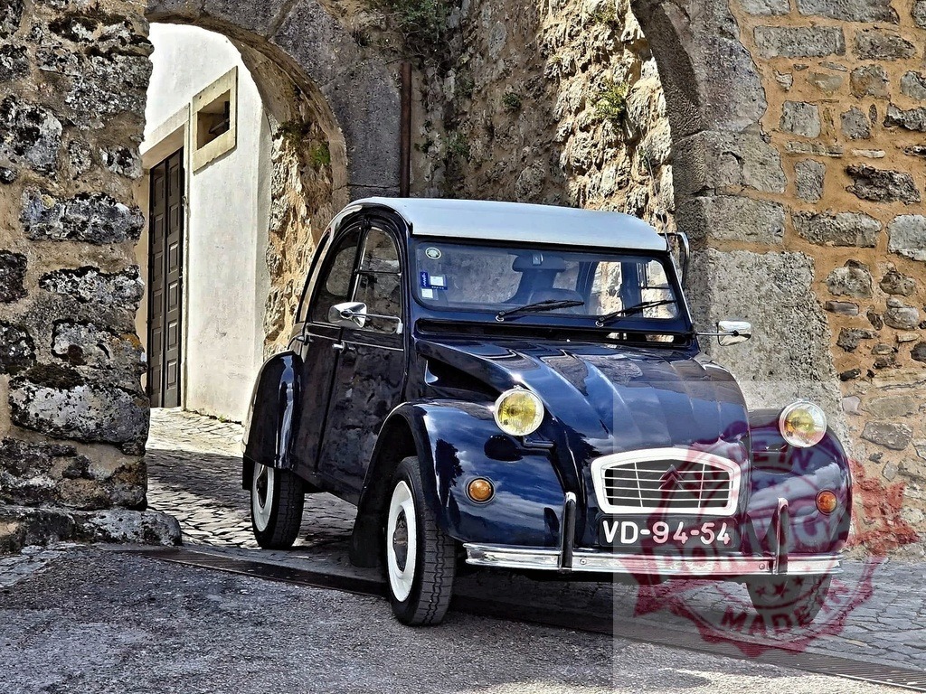 Classic Citroën 2CV parked under stone arch in Óbidos, Portugal | Blue vintage car parked under an arch in the medieval town of Óbidos, Portugal, representing travel and history - Realisiert mit Pictrs.com
