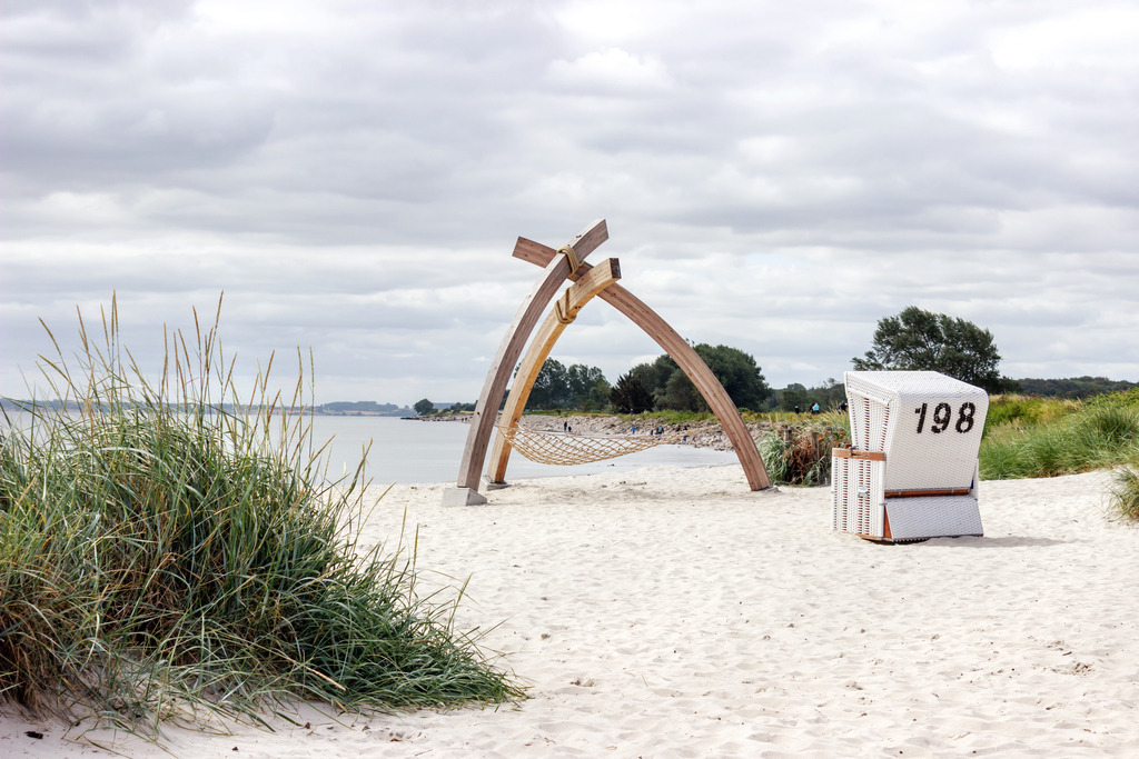 Wandbild: Strandkorb und Netzausleger am Strand in Damp | Dieses Wandbild im Querformat zeigt einen Strandkorb in weiß am Sandstrand am Sandstrand in Damp. Auf der linken Seite befindet sich Strandhafer. Holen Sie sich mit diesem dekorativen Wandbild den Strandurlaub für das ganze Jahr nach Hause oder an den Arbeitsplatz. Es ist auf Leinwand, auf Alu-Dibond, Acrylglas oder als Holzdruck erhältlich. Die Wandbilder werden individuell für Sie in vielen Abmessungen produziert. Daher passen die Ostseekult Wandbilder immer perfekt an Ihre Wände. - Realisiert mit Pictrs.com