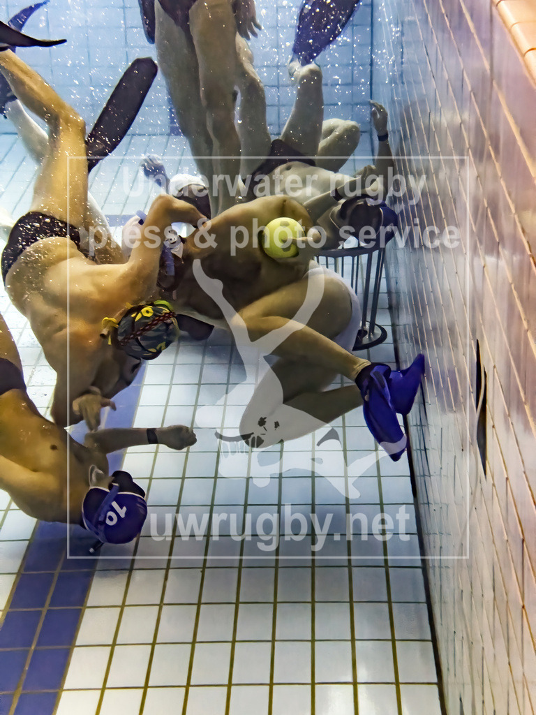Zweikampf beim Unterwasser-Rugby | Der weiße Spieler versucht sich mit dem Ball vom der Wand in Richtung Spielfeldmitte abzustoßen und sich so aus dem Zweikampf zu befreien. - Realisiert mit Pictrs.com