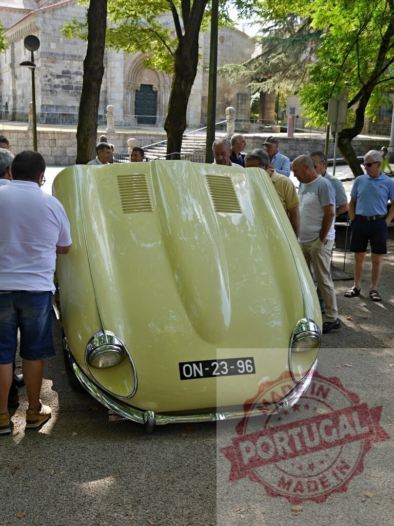 Men observing a vintage Jaguar E-Type at car show in Portugal | Men admiring a classic yellow Jaguar E-Type with an open hood at an outdoor car show - Realized with Pictrs.com