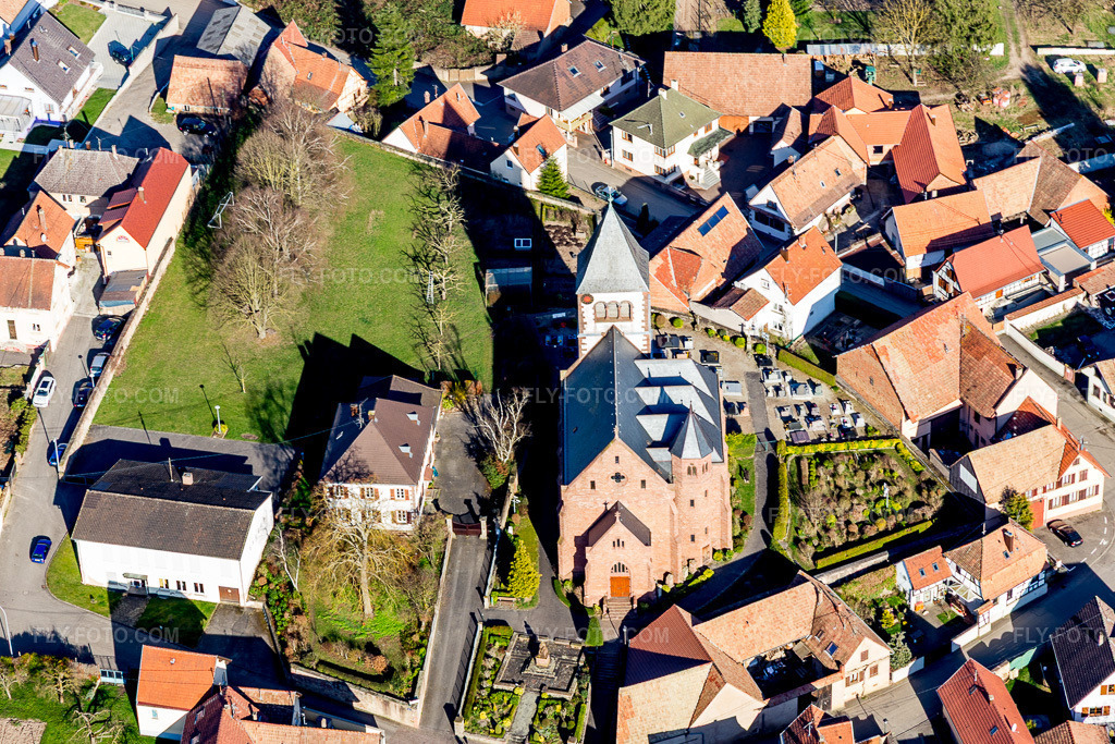 Aerial view: Church building and cemetery of the Église protestante luthérienne in the village center in Schwindratzheim in the state Bas-Rhin, France. – Photo: IMG_097594.jpg taken on 03/16/2017 by Werner Riehm/FLY-FOTO.com – Resolution of the original: 5035 x 3357 px