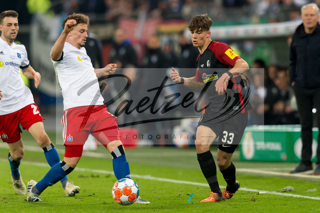HSVSCF20220419_144 | Fussball, Herren: Moritz Heyer (Hamburger SV) und Noah Weisshaupt (SC Freiburg) im Zweikampf beim DFB-Pokal-Halbfinalspiel zwischen Hamburger SV und SC Freiburg im Volksparkstadion am 19.04.2022 in Hamburg, Deutschland.DFB / DFL REGULATIONS PROHIBIT ANY USE OF PHOTOGRAPHS AS IMAGE SEQUENCES AND/OR QUASI-VIDEO. - Realisiert mit Pictrs.com
