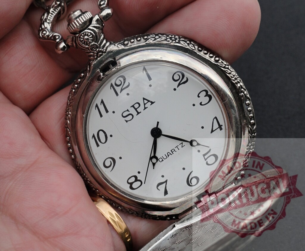 Hand holding vintage silver pocket watch showing time | Hand holding an ornate silver pocket watch with a white dial against a dark background - Realized with Pictrs.com