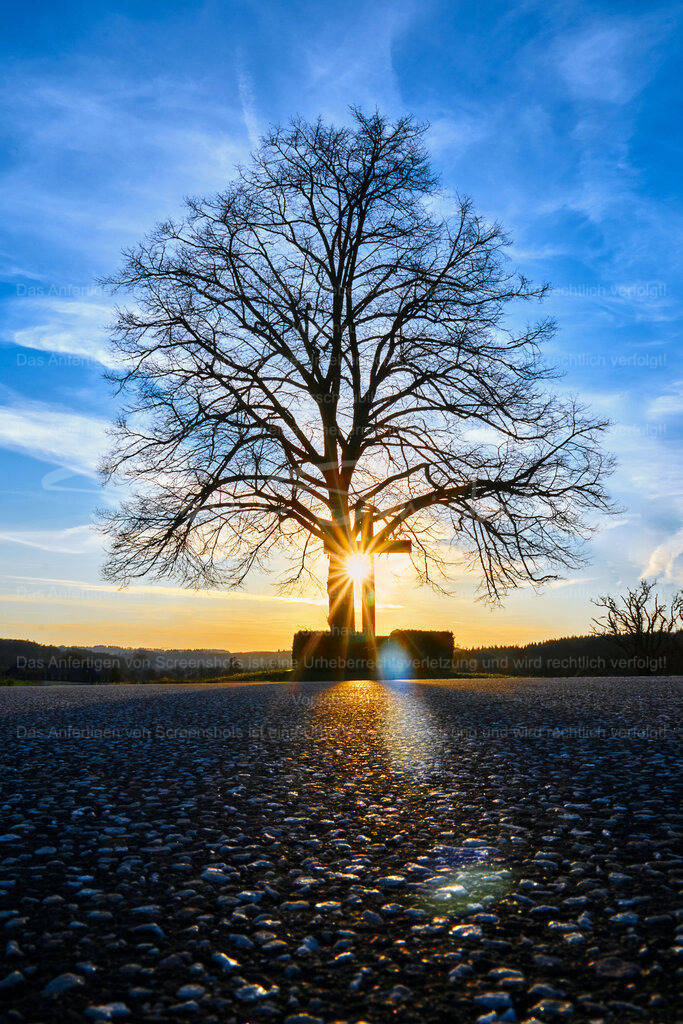 Auf dem Weg zum Kloster Martental | Vor einem strahlend blauen Himmel versinkt die Sonne hinter dem Kreuz und zaubert einen himmlischen Blendenstern - Realisiert mit Pictrs.com