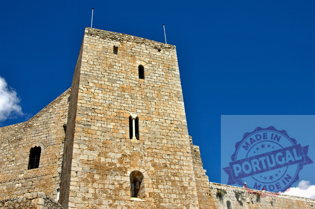 Castillo de Peñíscola medieval fortress tower under blue sky. Provincia Castellon - Spain | Castillo de Peñíscola's ancient stone walls and towering structure standing against a clear summer sky - Realized with Pictrs.com