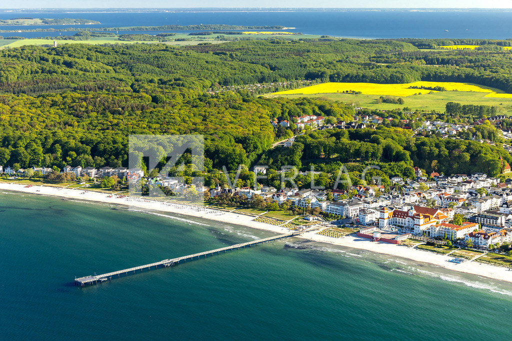 Wandbild-Binz-Luftbild-Ostsee-0U3A2866 | Das berühmte Ostseebad Binz mit seinem markanten Kurhaus an der Strandpromenade und der Seebrücke von leuchtenden Rapsfeldern umgeben. - Realisiert mit Pictrs.com