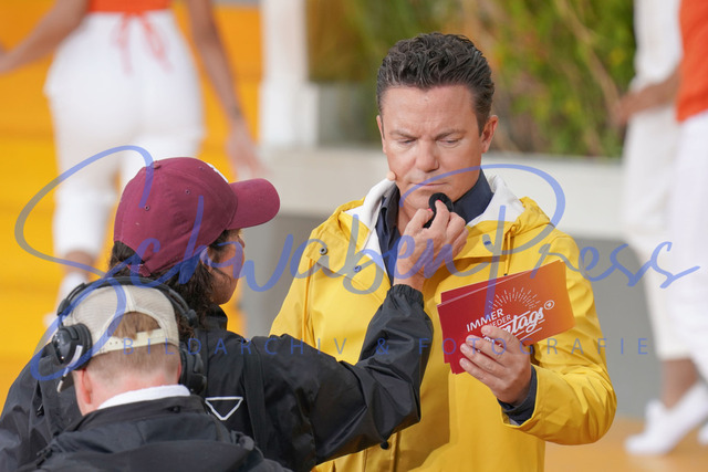 060823Ho2593 | Stefan Mross erstmals bei einem Auftritt mit Regenmantel wird von der Maskenbildnerin gepudert - Immer wieder sonntags


Die 10. Staffel der beliebten Sonntags Fernseh Show war von viel Regen begleitet. Ein Musikmix sorgte fuer Unterhaltung. 

Deutschland, Rust, Europapark Wasserwelt Rulantika, 06.08.2023