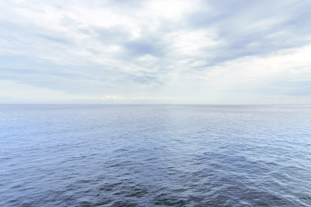 Weite See – Ruhe unter sanften Wolken | Dieses Motiv zeigt die weite, ruhige Oberfläche des Meeres unter einem sanft bewölkten Himmel. Die leichte Bewegung des Wassers erzeugt feine Strukturen, die das Licht subtil reflektieren und der Szene Tiefe verleihen. Über dem Horizont ziehen weiche Wolken, die die offene Weite und die natürliche Gelassenheit des Moments betonen. Die minimalistische Komposition vermittelt Stille, Klarheit und die beruhigende Kraft des Meeres. Als Wandbild erhältlich auf Acrylglas und weiteren hochwertigen Materialien.
