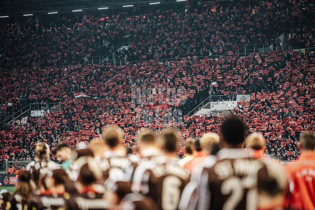 Fußball | Männer | Saison 2025/2026  | Fußball-Bundesliga | 11. Spieltag | FC St. Pauli vs. 1. FC Union Berlin | 23.11.2025 | Die Mannschaften laufen ins Stadion ein, auf den Tribünen werden Schilder mit no IMK hochgehalten No International Migration Conference gegen Internationale Migrationskonferenz