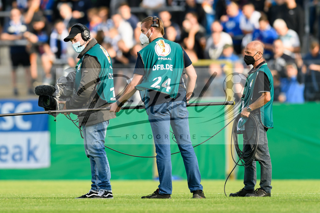 LOTKSC20210809_063 | Fussball, Herren: . Mitarbeiter vom Fersehen filmen das Einlaufen der Mannschaften beim Spiel der 1. Runde im DFB-Pokal zwischen SF Lotte und Karlsruher SC im Stadion am Lotter Kreuz am 09.08.2021 in Lotte, Deutschland.DFB / DFL REGULATIONS PROHIBIT ANY USE OF PHOTOGRAPHS AS IMAGE SEQUENCES AND/OR QUASI-VIDEO. - Realisiert mit Pictrs.com
