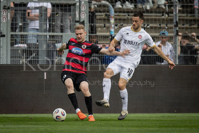 Viktoria Koeln vs. SV Wehen Wiesbaden, 11.04.2026 | KOELN, GERMANY - APRIL 11, 2026:  Meiko Sponsel (Viktoria Köln, 19), Robin Kalem (SV Wehen Wiesbaden, 10) during the 3rd division match between Viktoria Koeln vs. SV Wehen Wiesbaden at the Sportpark Hoehenberg on matchday 7 on April 11, 2026 in Koeln, Germany. DFL REGULATIONS PROHIBIT ANY USE OF PHOTOGRAPHS AS IMAGE SEQUENCES AND/OR QUASI-VIDEO.