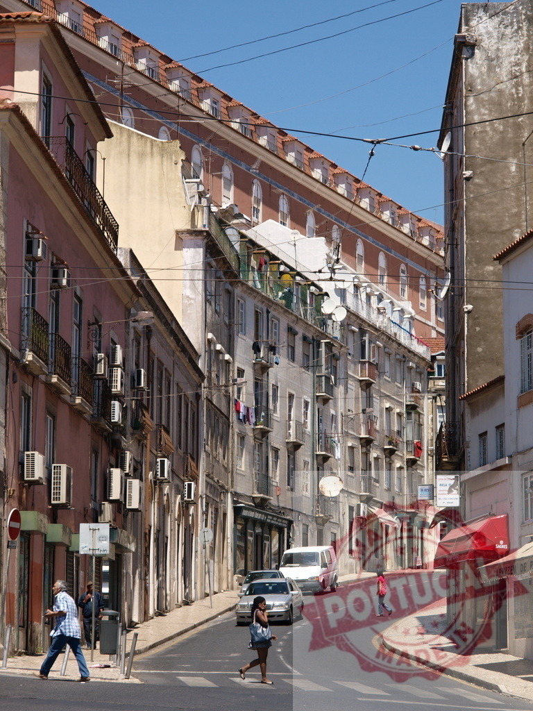 Lisbon street scene with traditional portuguese architecture and people walking | People walking on a curving street lined with traditional buildings and air conditioning units - Realized with Pictrs.com