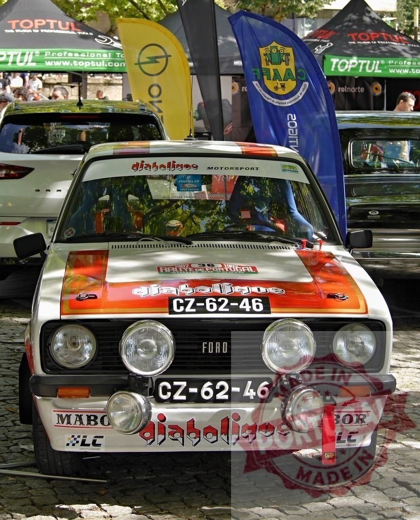 Ford Escort MkII vintage rally car displaying decals | Ford Escort MkII classic rally car on display at a motorsport event - Realized with Pictrs.com