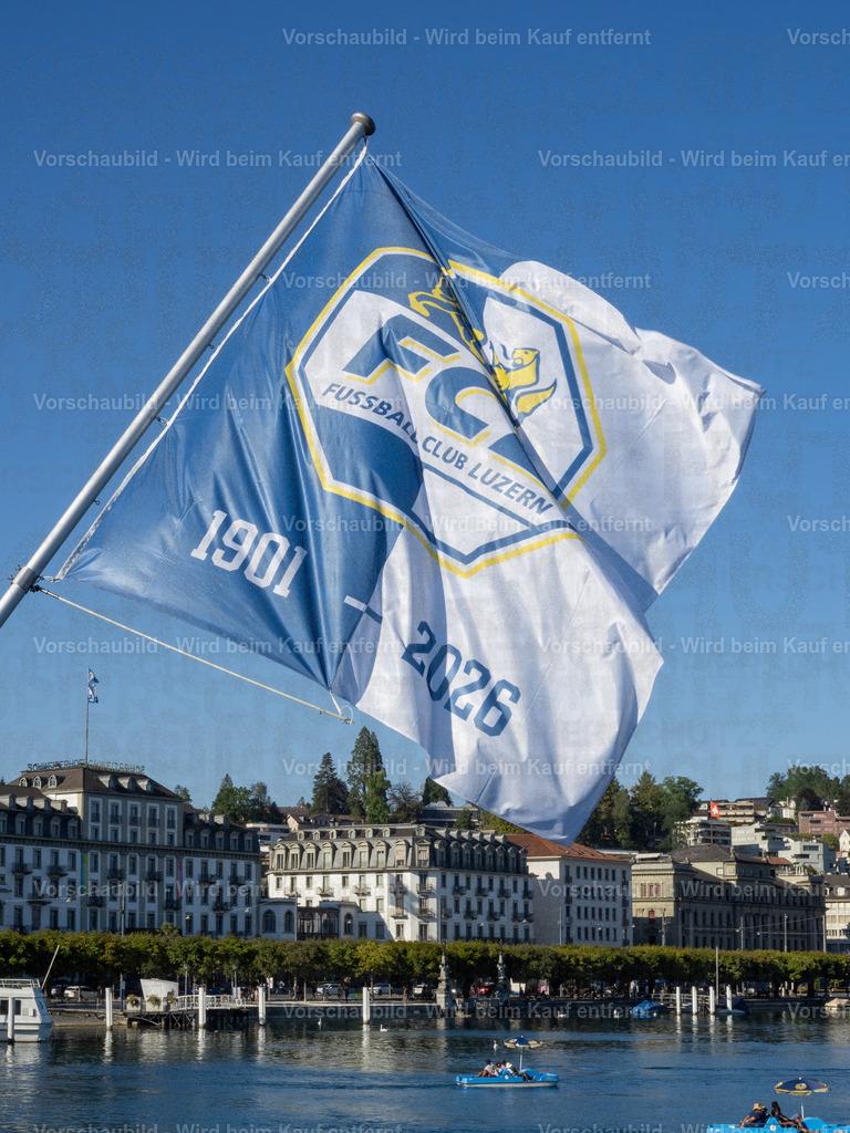 125 Jahre FCL – Luzern in Blau-Weiss | Die blau-weissen Fahnen wehen an der Seebrücke im Wind und zelebrieren das 125-Jahre-Jubiläum des FC Luzern. Dahinter erstreckt sich die Kulisse der Luzerner Seepromenade mit dem traditionsreichen Hotel Schweizerhof. - Realisiert mit Pictrs.com