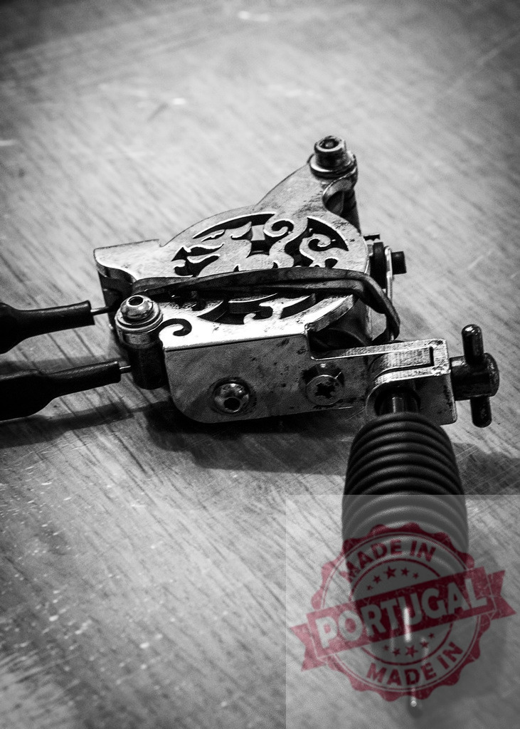 Professional tattoo machine setup with black and white aesthetic | Classic tattoo machine resting on a wooden surface, showing details of tattoo art equipment - Realisiert mit Pictrs.com