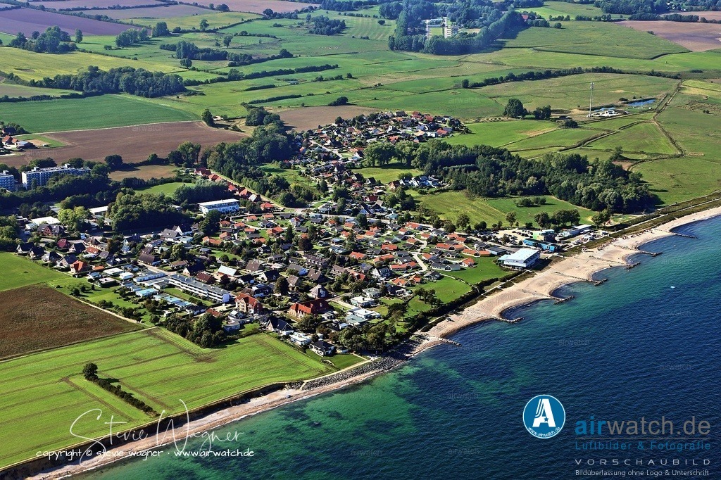 Luftbilder Schönhagen - mit  feinsandige, flach abfallende Strand | Der feinsandige, flach abfallende Strand in Schönhagen ist ideal für Familien mit Kindern – zum Planschen, Sandburgen bauen und Muscheln sammeln. Der Strand ist in verschiedene Bereiche unterteilt: Es gibt Strandkörbe, einen FKK-Abschnitt und zwei ausgewiesene Hundestrände (Nord und Süd), an denen Hunde auch außerhalb der Saison erlaubt sind. An der Südspitze des Ortes erstreckt sich die geschützte Steilküste, ein beeindruckendes Naturdenkmal mit Ausblicken auf die Ostsee. Nach stürmischen Tagen lassen sich am Fuß der Steilküste oft Bernstein und Fossilien finden.