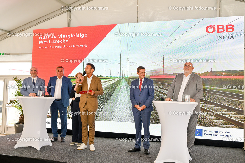 Festakt_ OeBB Gleisausbau_ Baustart_ 01.07.2024-10 | 01.07.2024, Hoersching, AUT, Festakt OeBB-anlaesslich des 4-gleisigen Ausbau des Abschnitt Linz - Marchtrenk, im Bild Wolfgang Bogensberger (Leiter der Vertretung der EU Kommission in Oesterreich), LR Guenther Steinkellner (FP), BMin Leonore Gewessler (Die Gruenen, Klimaschutz, Umwelt, Energie, Mobilitaet, Innovation und Technologie), Moderator, Leo Leitner, LR Markus Achleitner (VP), Andreas Mattae (Vorstandvorsitzender der OeBB)
