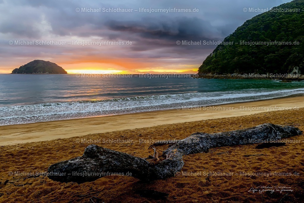 Sonnenuntergang in der Onetahuti Bay, Neuseeland | Dramatischer Sonnenuntergang Ã¼ber der Onetahuti Bay im Abel Tasman Nationalpark, Treibholz im Vordergrund am goldenen Sandstrand. - Realisiert mit Pictrs.com