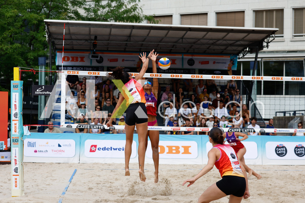 Obi BeachTour 2026 - Basel | BASEL, SWITZERLAND - JULY 17: SHANA ZOBRIST (SUI) attack / spike against ELENA CSONTOS (SUI) block during the Obi BeachTour 2026 match between ZOBRIST / LUTZ (SUI) and CSONTOS / DEECKE (SUI) at Barfüsserplatz on July 17, 2026 in Basel, Switzerland. - Realisiert mit Pictrs.com