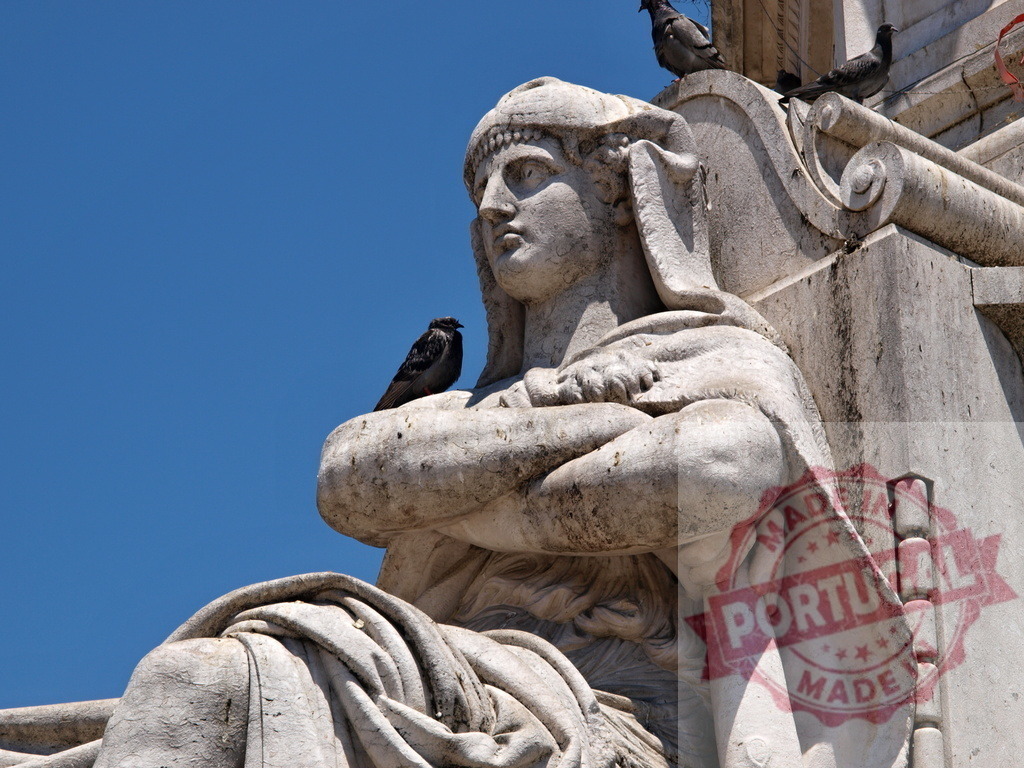 Stone statue of a woman with bird resting on arm | Stone statue of a woman with a bird resting on her arm against a clear blue sky - Realized with Pictrs.com