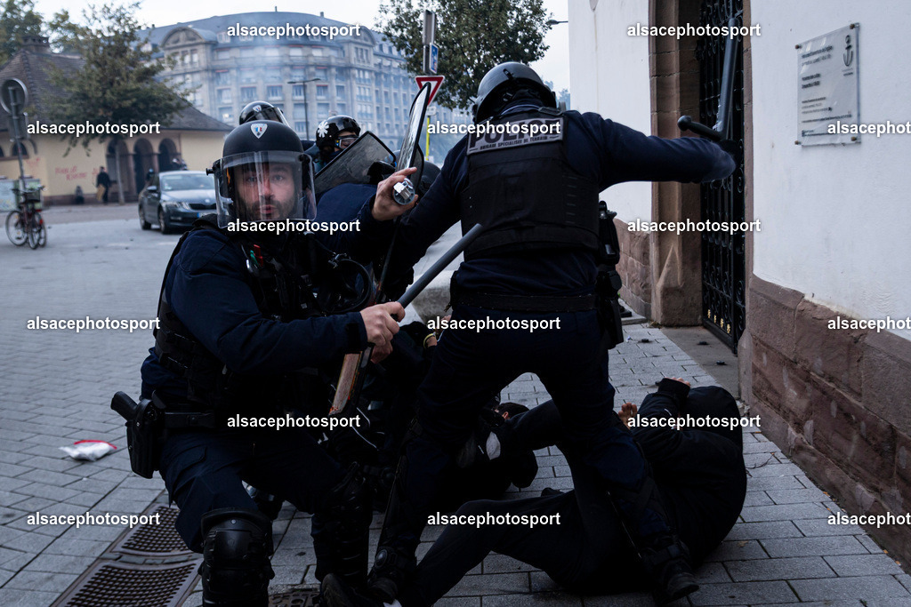 9L6A6979 | Strasbourg, France, 24 octobre 2026. Des manifestants affrontent les forces de l’ordre lors d’une mobilisation dans le centre-ville de Strasbourg. Des policiers interviennent pour disperser des groupes de manifestants, tandis que des gaz lacrymogènes sont utilisés. Des affrontements, des jets de projectiles et des dégradations sont observés dans plusieurs rues. Des barricades et des véhicules en feu témoignent de la tension qui règne en marge de la mobilisation. - Realisiert mit Pictrs.com