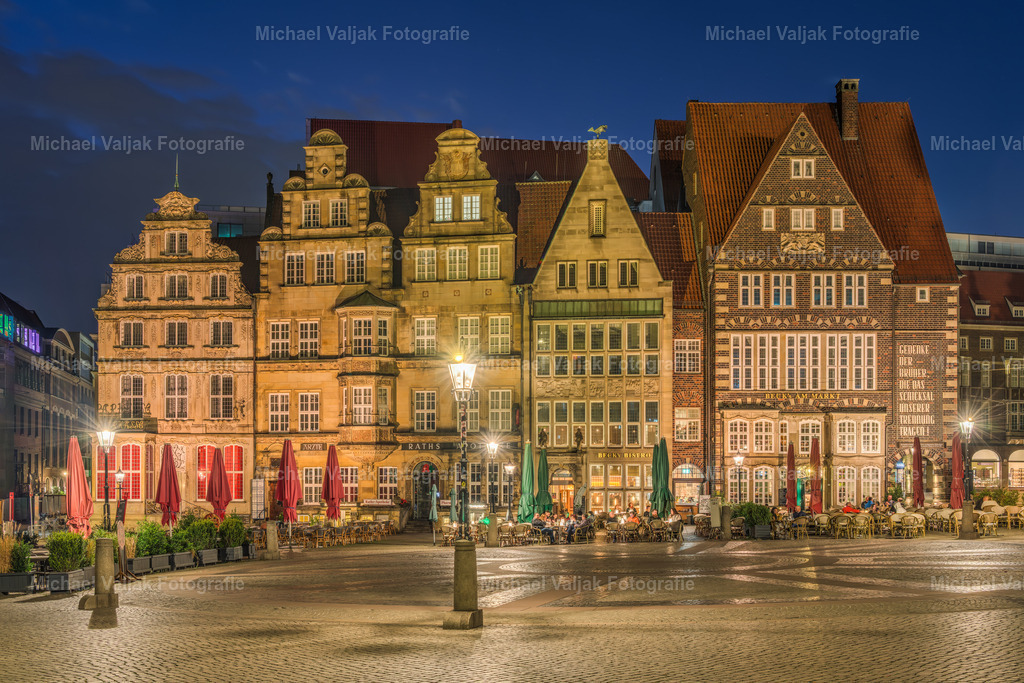 Bremen Häuser am Markt | Bei Nacht wirken die giebelständigen Häuser am Bremer Marktplatz wie stumme Zeugen vergangener Jahrhunderte. Ihre Fassaden, geprägt von Backstein, Sandstein und kunstvollen Ornamenten, treten im warmen Licht der Straßenlaternen besonders plastisch hervor. Die Giebel zeichnen sich scharf gegen den dunklen Himmel ab, jede Linie scheint bewusst gesetzt, jede Form erzählt von hanseatischer Baukunst und Kaufmannstradition. - Realisiert mit Pictrs.com