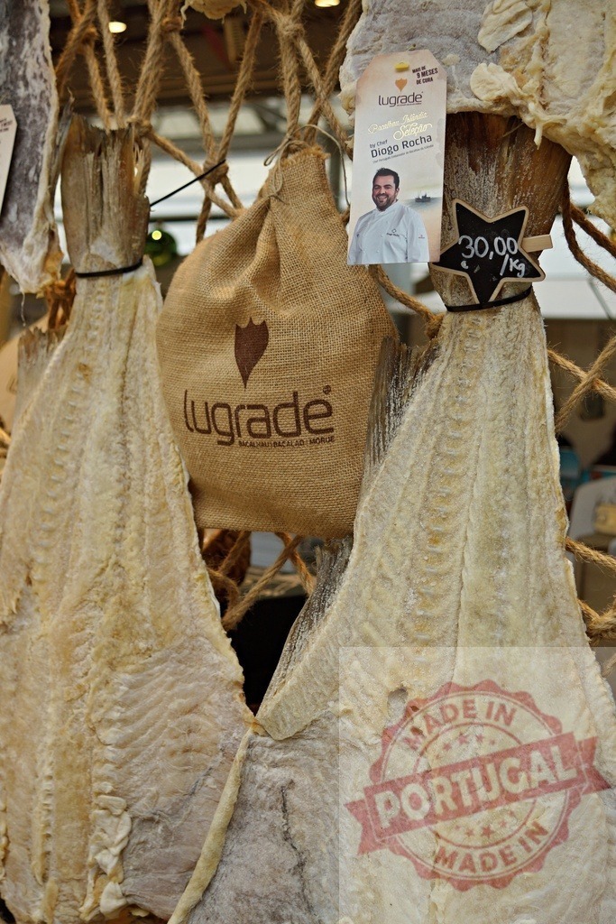 Bacalhau salted cod fish hanging for sale | Dried and salted cod fish hanging from rope display at a market with information tag - Realisiert mit Pictrs.com