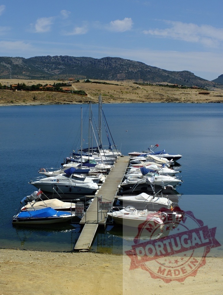 Marina dock with boats mooring in a lake. Spain - Extremadura | Boats and yachts mooring at a floating dock on a large lake with mountains - Realized with Pictrs.com