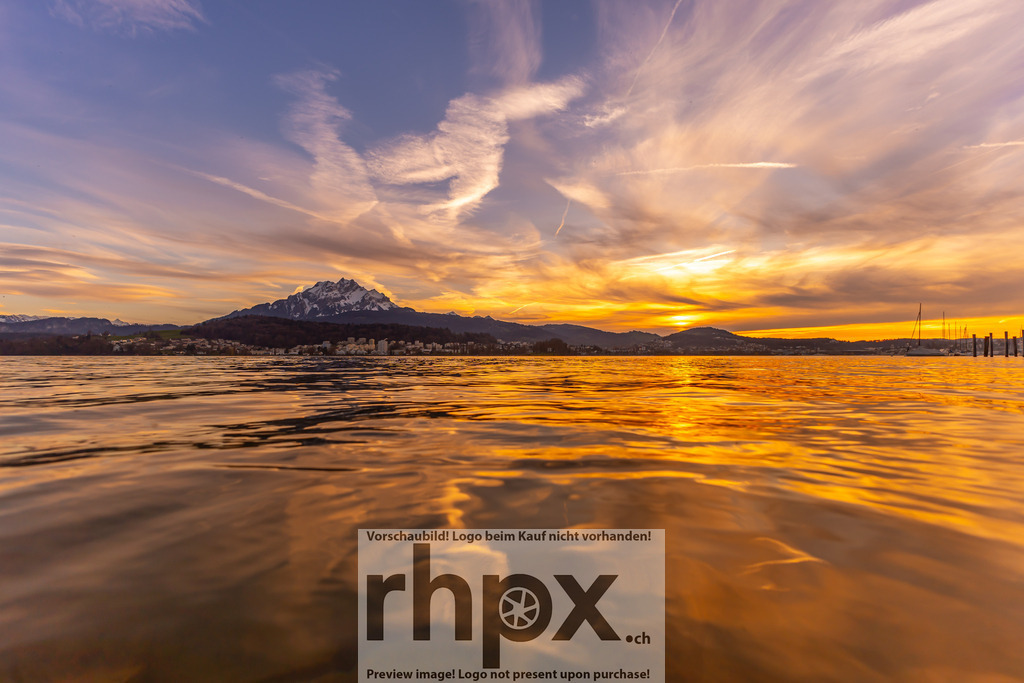 Sonnenuntergang mit Pilatus | Horizont. Gold. Stille.Ein weiter Panoramablick über den Vierwaldstättersee, bei dem Himmel und Wasser in warmen Goldtönen miteinander verschmelzen. Der majestätische Pilatus bildet den ruhenden Pol in dieser friedlichen Abendstimmung, während sanfte Wolken das letzte Sonnenlicht einfangen.Wähle unter "Produktauswahl" dein Wunschformat: Vom klassischen Wandbild über Puzzle &amp; Tassen bis zum digitalen Download (z.B. als Handy-Hintergrund). - Realisiert mit Pictrs.com