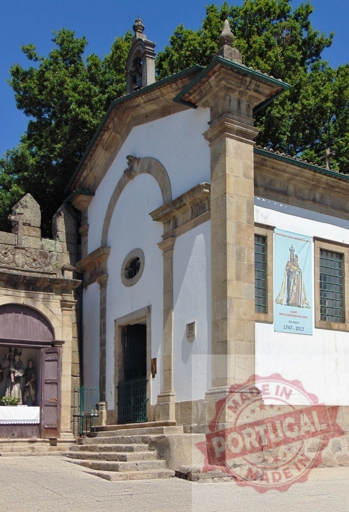 Portuguese chapel facade with bell tower and saint statues. Region Norte - Portugal | Chapel facade featuring a bell tower, stone details, and religious statues - Realisiert mit Pictrs.com