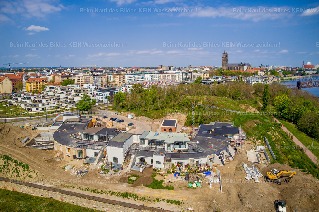Magdeburg Elbbahnhof-0093 | Senkrechter Blick aus der Drohne auf das Kavalier Scharnhorst nahe der Sternbrücke. Aus dieser Perspektive wird die ungewöhnliche Form des historischen Festungsbauwerks besonders deutlich. Die Aufnahme zeigt die Anlage nahezu wie einen Grundriss und macht sichtbar, wie stark sich ihre ursprüngliche Struktur bis heute erhalten hat.Das Kavalier Scharnhorst gehört zu den erhaltenen Zeugnissen der einstigen Festungsstadt Magdeburg. Das Bauwerk entstand als Teil der umfangreichen Befestigungsanlagen und wurde zu einem großen Teil aus Erde und massiven Befestigungskonstruktionen errichtet. Seine ursprüngliche Aufgabe war die Verteidigung der Stadt und der wichtigen Übergänge über die Elbe.Heute erlebt dieser historische Ort eine ungewöhnliche neue Nutzung. Die Magdeburger Unternehmer Onnen &amp; Onnen entwickeln das ehemalige Festungsbauwerk zu modernen Wohnhäusern und verbinden damit historische Bausubstanz mit zeitgemäßem Wohnen.Gerade aus der senkrechten Drohnenperspektive wird dieser Wandel besonders anschaulich: Die einstige militärische Anlage aus Erde liegt heute mitten in einem modernen Stadtquartier.Was früher der Verteidigung Magdeburgs diente, wird heute zum Zuhause. Ein Beispiel dafür, wie sich Geschichte verändern kann, ohne dass ihr Ort verschwindet. - Realisiert mit Pictrs.com