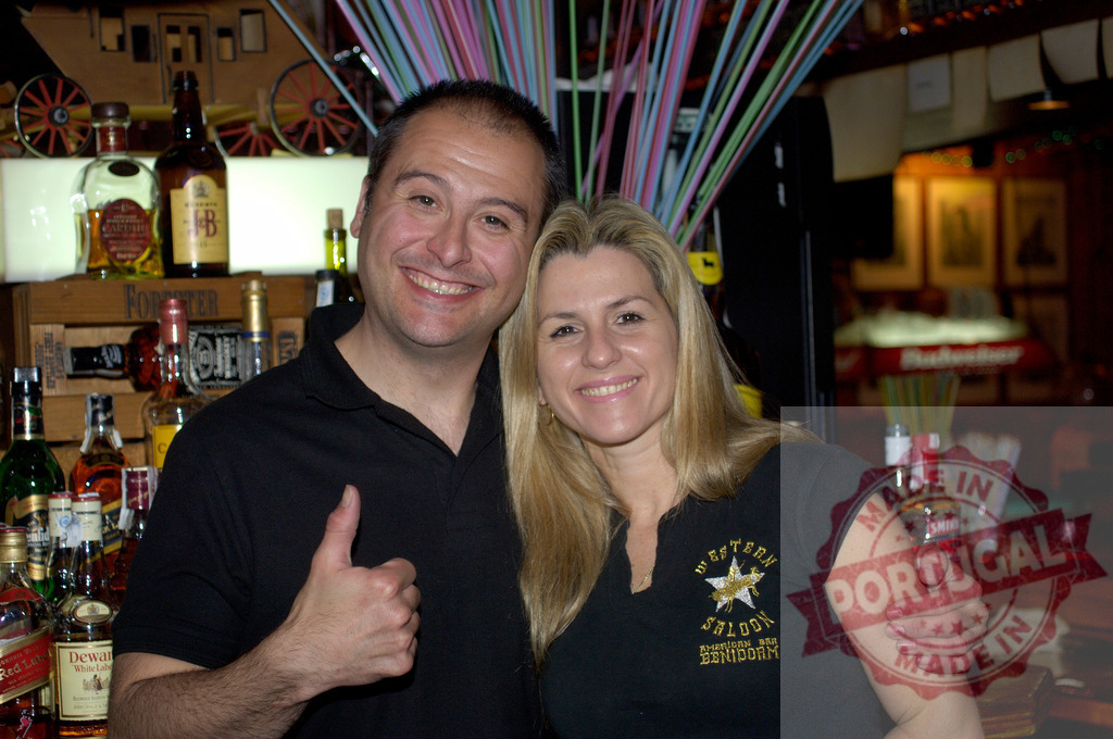 Smiling couple celebrating success enjoying bar atmosphere | Happy couple smiling and posing with thumbs up for approval in a pub - Realized with Pictrs.com