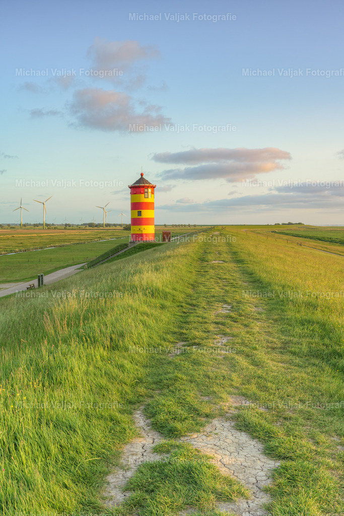 Pilsumer Leuchtturm in Ostfriesland | Blick vom Deich zum Pilsumer Leuchtturm. Der Leuchtturm ist ein Wahrzeichen Ostfrieslands und vor allem aus dem Film "Otto - der Außerfriesische" bekannt. Er ist dadurch einer der bekanntesten Leuchttürme Deutschlands.Der Turm weist eine leichte Schieflage nach Osten auf (im Bild links). Im Laufe der Jahrzehnte hat er sich durch den oft starken Wind in diese Schräglage begeben, da das Fundament selbst nicht auf Stützen steht. Es handelt sich hierbei also nicht um einen Bildfehler. - Realisiert mit Pictrs.com