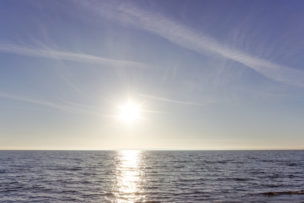 Wandbild: Licht über der See | Pure Freiheit für Ihre Wände. Dieses Wandbild zelebriert die unendliche Weite der Ostsee in einem Moment vollkommener Stille. Das sanfte Glitzern der Wellen im Gegenlicht der tiefstehenden Sonne verschmilzt am Horizont mit dem weichen Blau des Himmels. Ein minimalistisches Meisterwerk, das Ruhe in jeden Raum bringt und Ihren Blick in die Ferne schweifen lässt. Ideal für alle, die das Meer in seiner reinsten und friedlichsten Form lieben. - Realisiert mit Pictrs.com