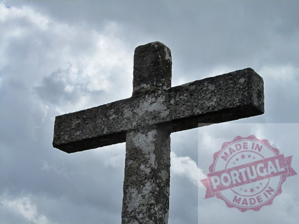 Stone christian cross against dramatic cloudy sky. Region Norte - Portugal | Stone cross standing under an overcast sky representing faith and spirituality - Realisiert mit Pictrs.com