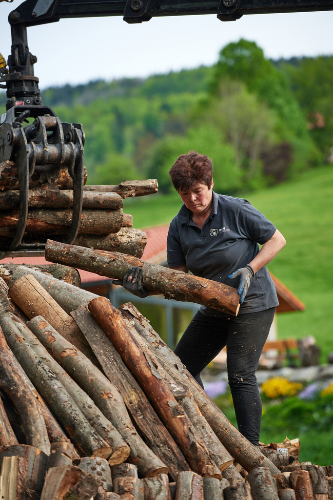 Frau Hochecker beim Aufbau des Kohlmeilers | Michelbach, Austria - May 08, 2019: Waldköhlerei Hochecker, die 2011 in das Nationale Verzeichnis des immateriellen Kulturerbes der UNESCO aufgenommen wurde, produziert noch echte Holzkohle; Frau Hochecker beim Aufbau des Kohlmeilers. - Realisiert mit Pictrs.com