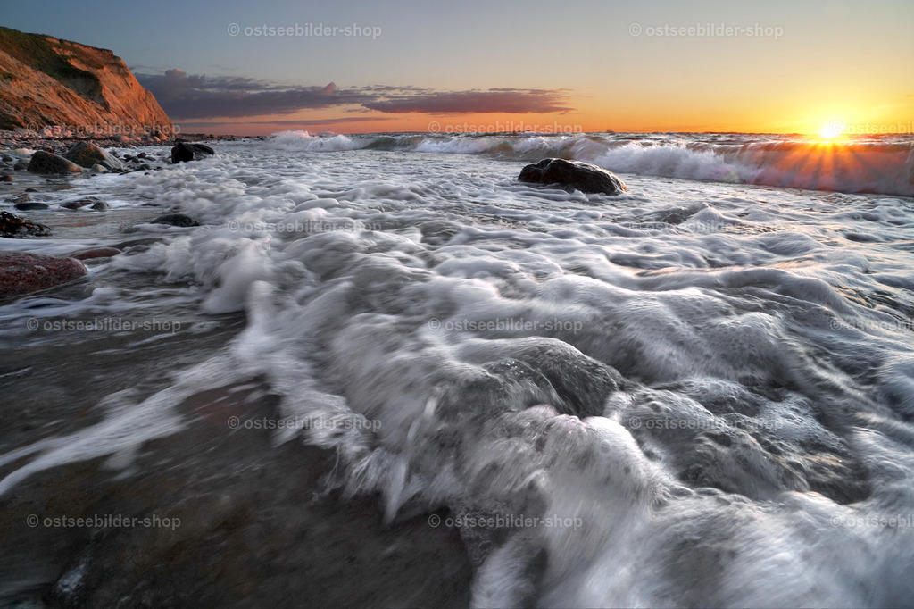 Wellenspiel im Abendlicht | Schäumend fluten Ostseewellen den Strand. Die Abendsonne versinkt gerade im Meer und schickt ihr Licht auf die Wellenkämme vor dem Strand.
