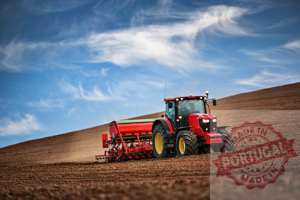 Red tractor planting seeds in field under blue sky | Tractor with seeder machine working on farmland, preparing soil for new season - Realized with Pictrs.com
