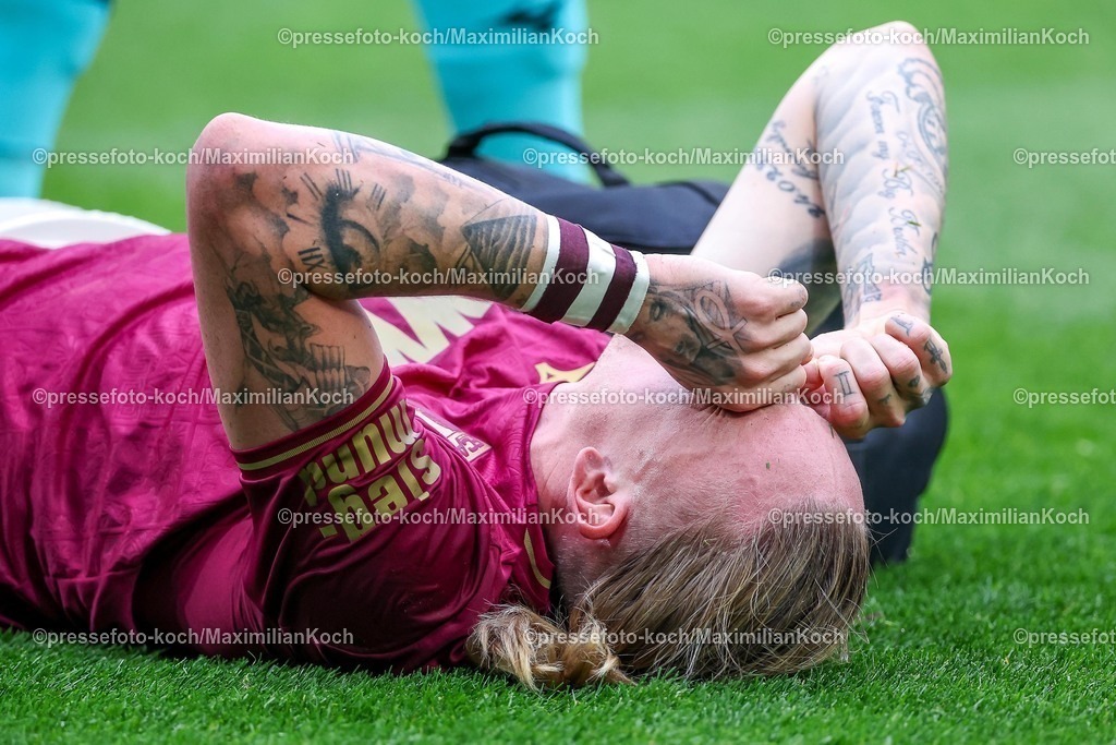 BMG21022502143 | 22.02.2025, Fußball, Borussia Mönchengladbach - FC Augsburg, 1. Fußball Bundesliga, Borussia-Park, Saison 2024 2025: Marius Wolf (FC Augsburg #11) liegt mit Schmerzen auf dem SpielfeldDFB regulations prohibit any use of photographs as image sequences and or quasi-video.
